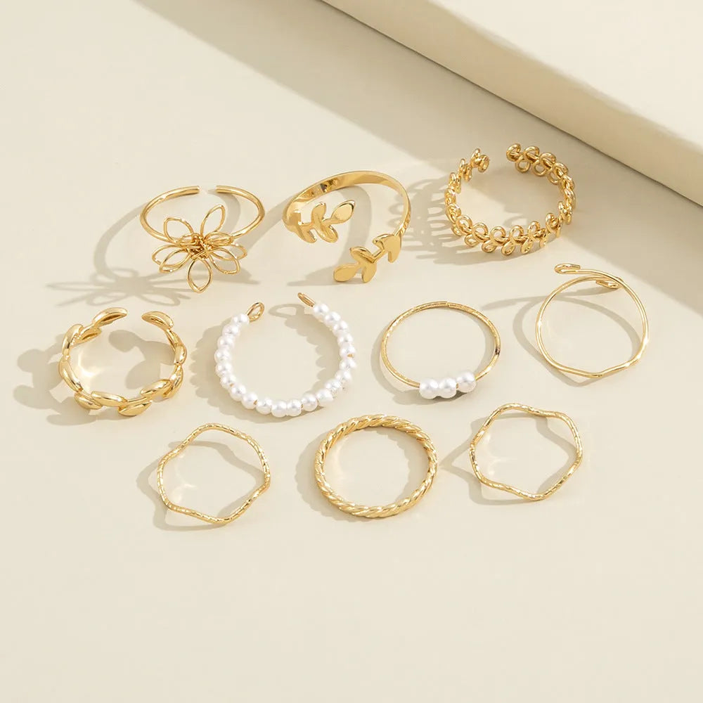 Women's gold openwork flower ring set showing detailed floral cut-out pattern and glossy electroplated finish