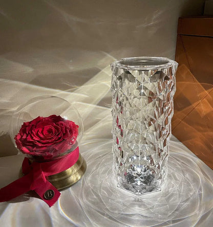 Modern minimalist acrylic crystal rose LED table lamp with touch switch on a wooden table.