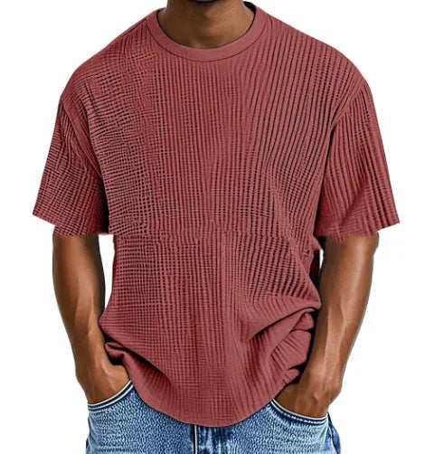 Man wearing a light blue waffle-textured cotton blend short sleeve t-shirt, casual pullover style.