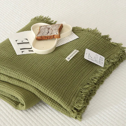 Four-layer gauze tassel blanket in cotton, showing tassel edges and textured fabric, available in multiple colours and sizes