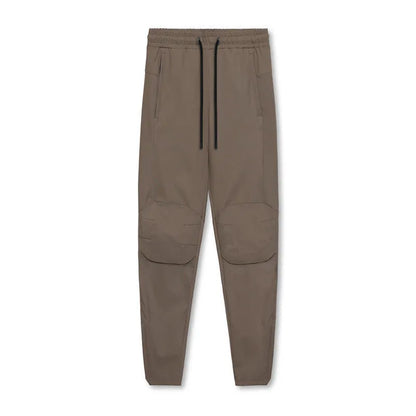 Men's grey fitness trousers with ankle ties, made from quick-drying polyester, for exercise and casual use.