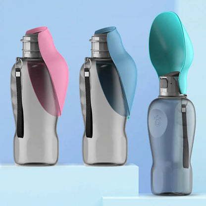 Blue grey portable dog water bottle with foldable drinking bowl and wrist strap, shown next to a dog.