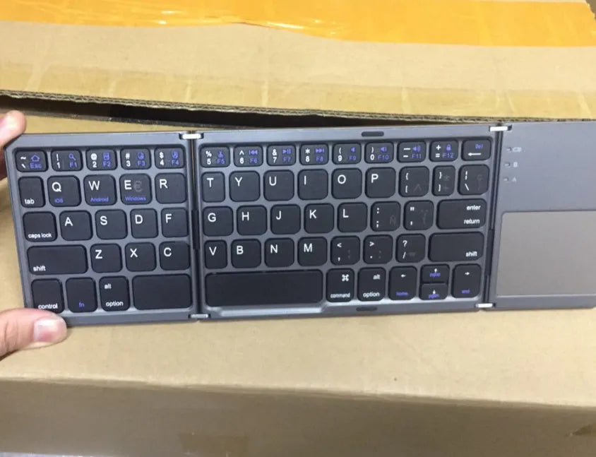 Tri-fold folding touch keyboard shown both unfolded for typing and folded for transport with touchpad