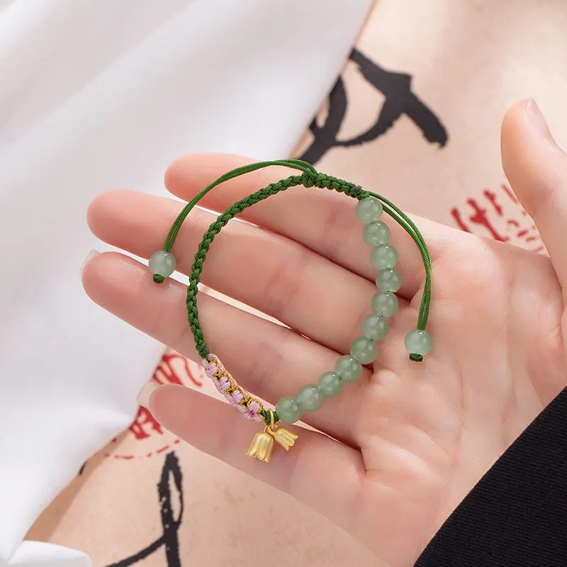 Hand woven red rope women's bracelet in Lily Carrying Strap colour with a flower element.