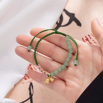 Hand woven red rope women's bracelet in Lily Carrying Strap colour with a flower element.