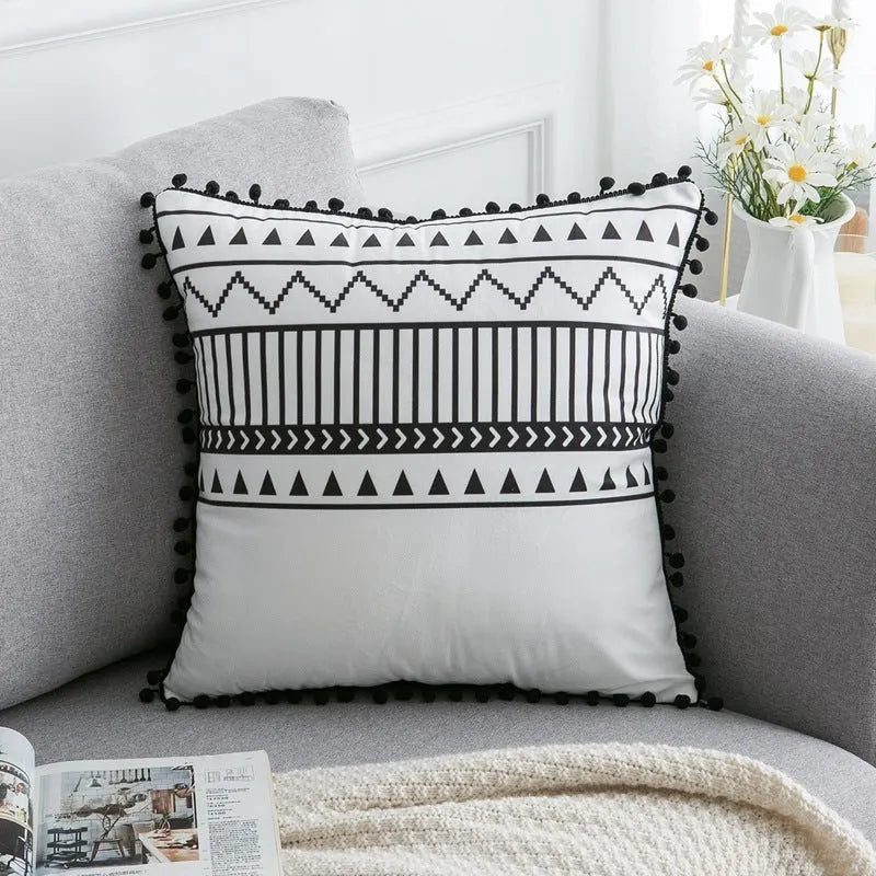 Bohemian style decorative pillowcase in light grey colour on a sofa.