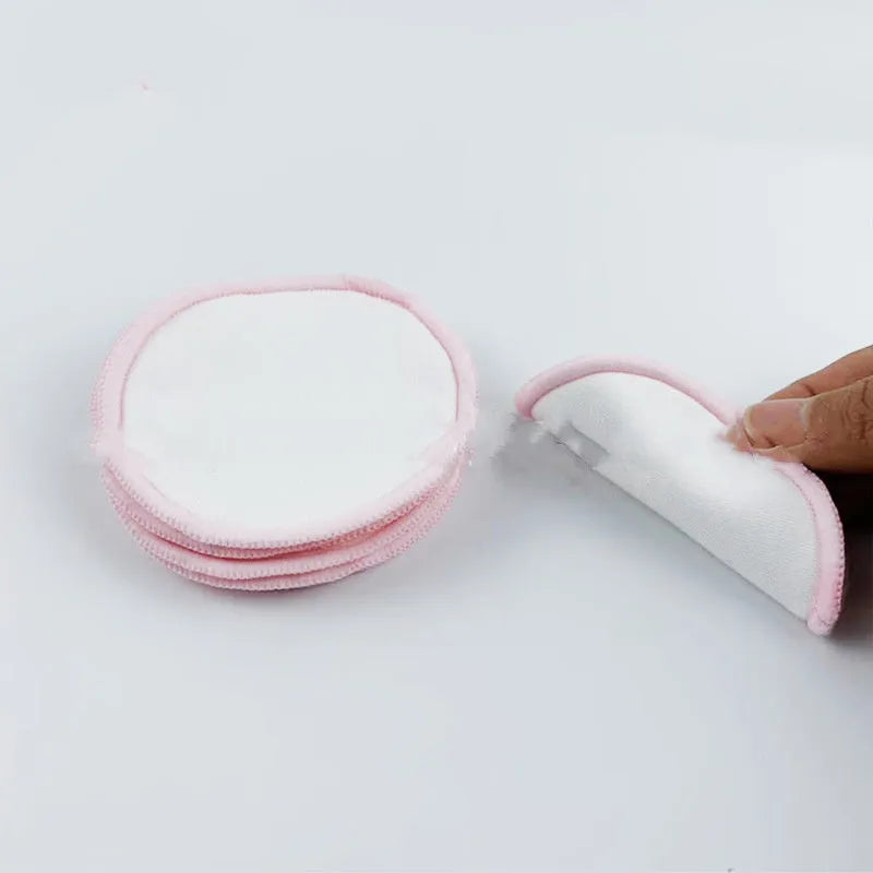 Set of water pink and light blue velvet makeup remover pads next to a cotton mesh storage bag.