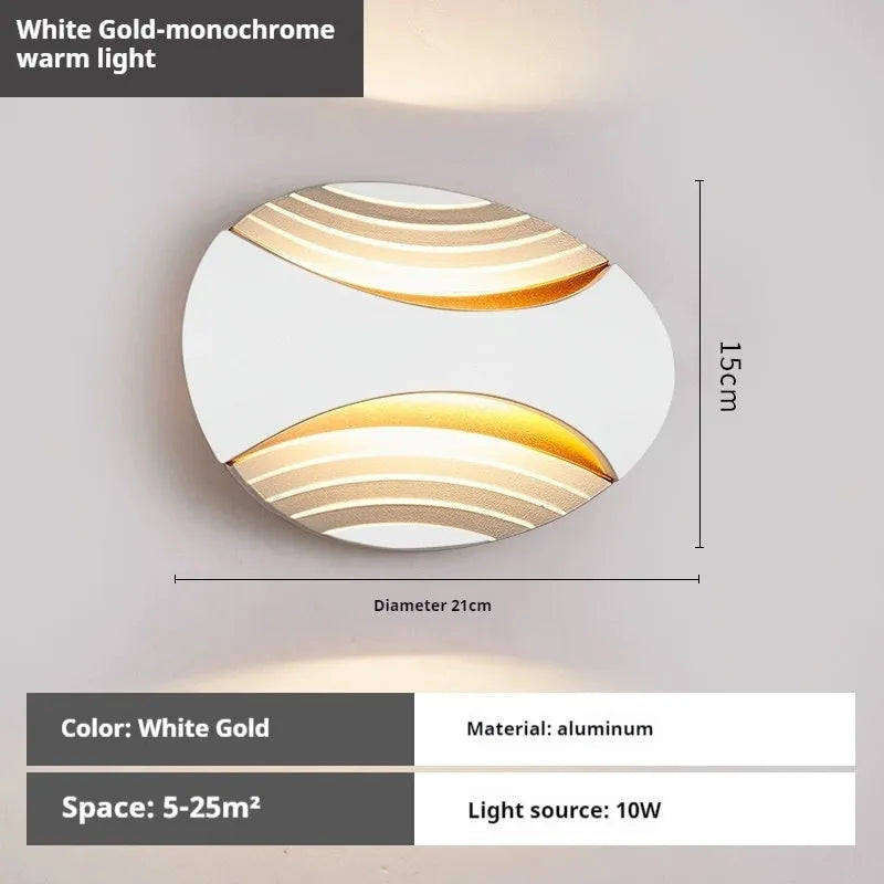 Modern aluminium wall lamp in black finish mounted beside a bed, emitting warm LED light.