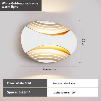 Modern aluminium wall lamp in black finish mounted beside a bed, emitting warm LED light.