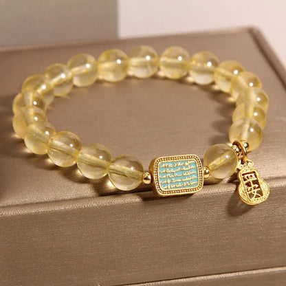 Women's bracelet made from yellow citrine crystal with rhinestone decoration on a white background.