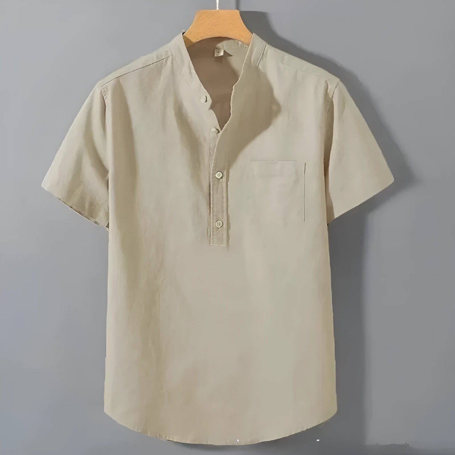 Man wearing a beige loose-fit linen blend casual shirt with a stand collar and short sleeves.
