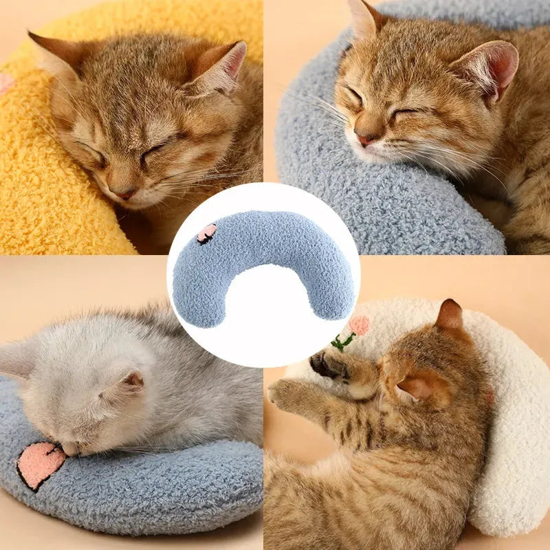 White U-shaped pet pillow measuring 27cm with raised rim supporting small cat's neck and back