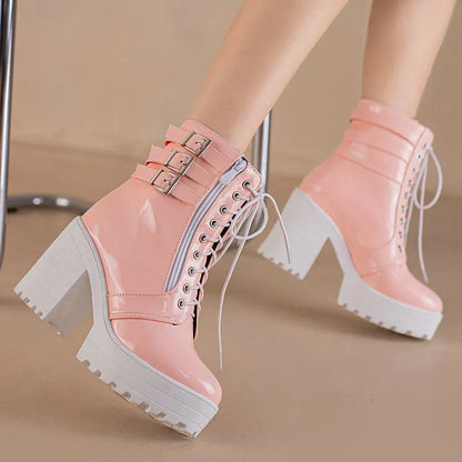 Women's black chunky heel ankle boots with round toe and front lace-up design on a wooden floor.