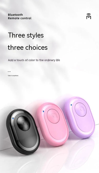 Small black wireless Bluetooth remote control for smartphone camera with self-timer function.