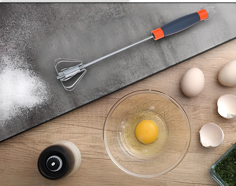 Stainless steel manual egg beater showing three size options with green and orange handles