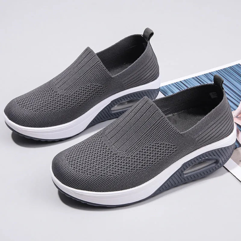 Women's beige mesh running shoes with round toe and air cushion midsole on a grey background.