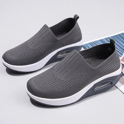 Women's beige mesh running shoes with round toe and air cushion midsole on a grey background.
