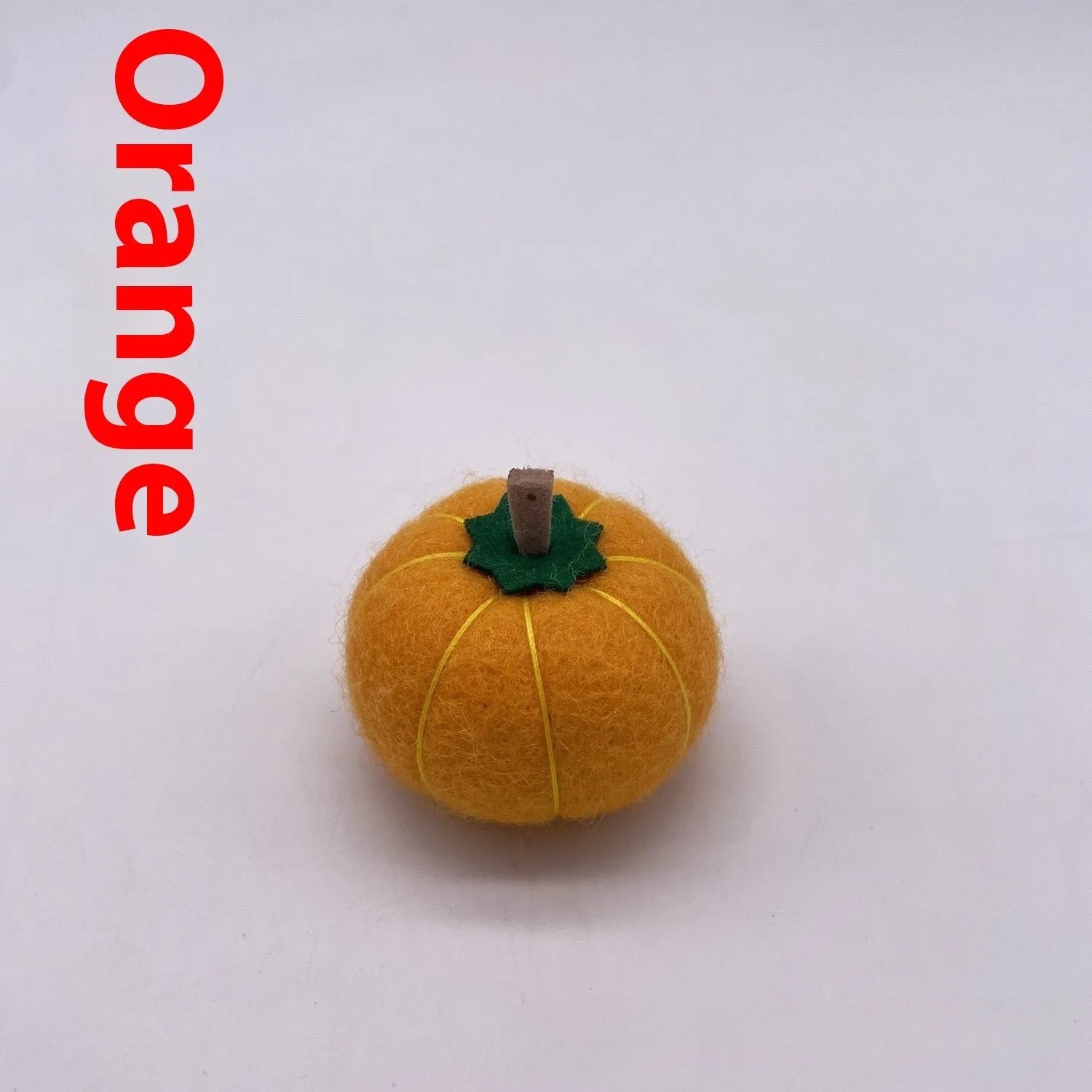 Wool felt pumpkin ornaments in various colours for doll decoration and craft projects.