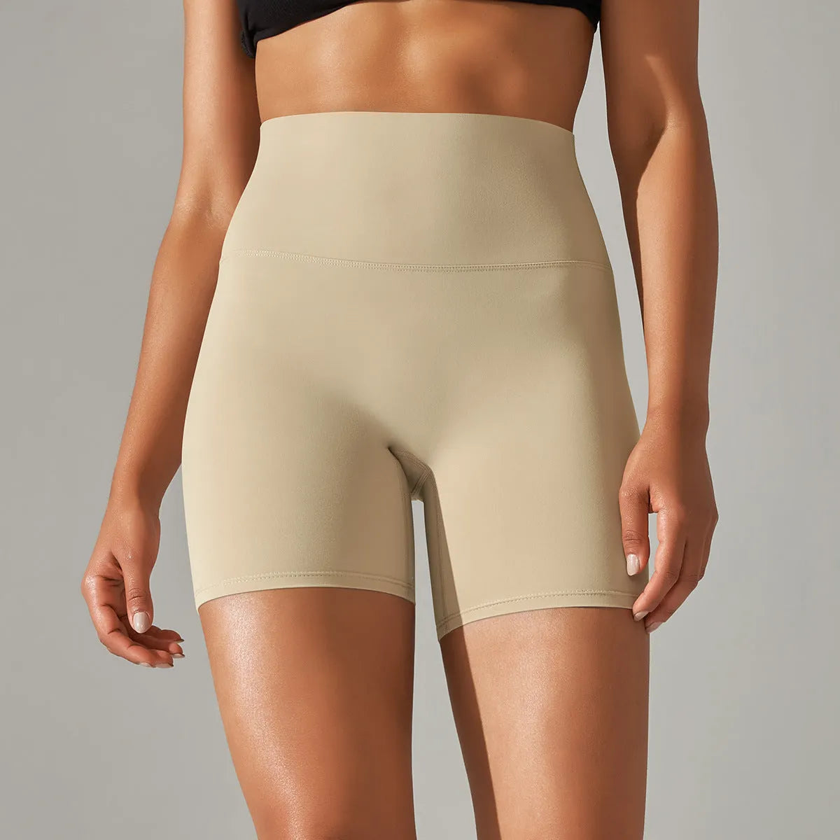 Woman wearing high waist hip lift fitness tights in a neutral colour, suitable for running or gym workout.
