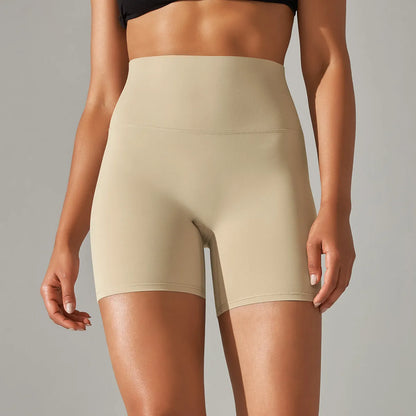 Woman wearing high waist hip lift fitness tights in a neutral colour, suitable for running or gym workout.