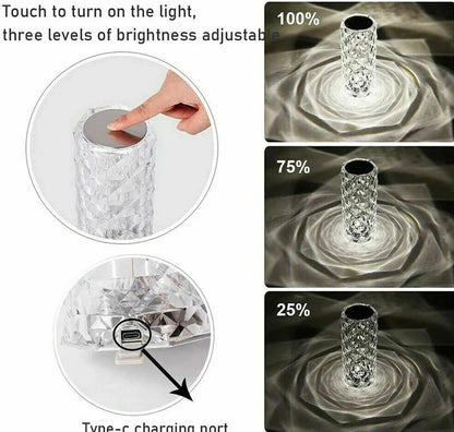 Clear acrylic LED table lamp with diamond-cut surfaces and remote control on wooden surface
