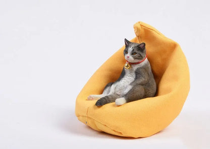 Lazy cat ornament on miniature sofa for car dashboard decoration, 7.5cm high with fabric art detailing