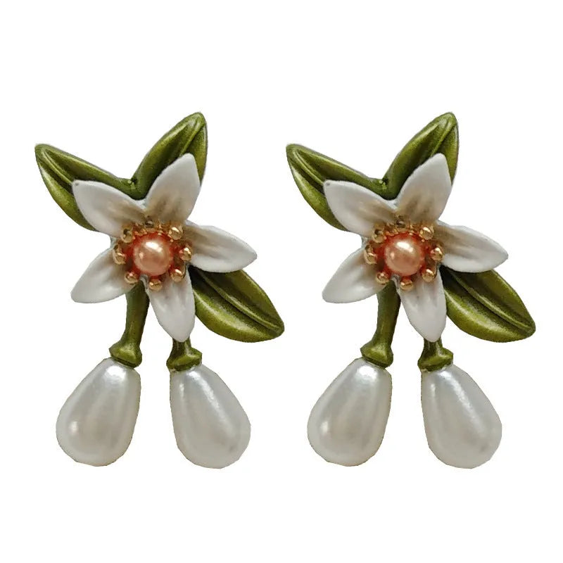A pair of alloy flower ear studs and a pair of matching flower ear clips with a sterling silver needle detail.