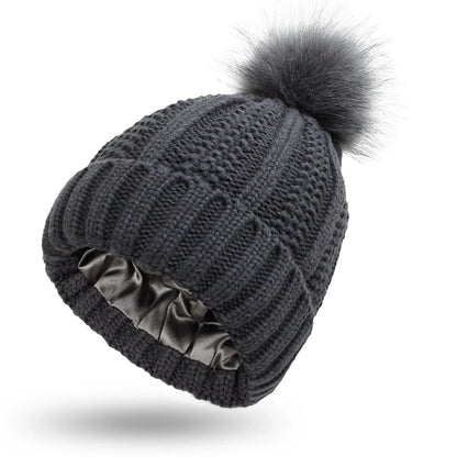 Cozy satin-lined knit beanie with plush faux fur pom-pom in various colors for women