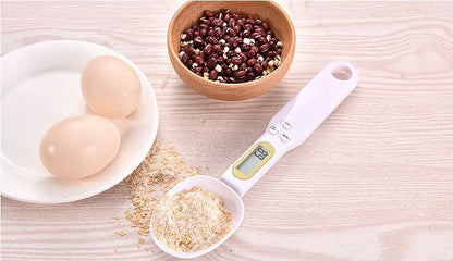 Black electronic measuring spoon scale showing digital display with spoon bowl for kitchen weighing