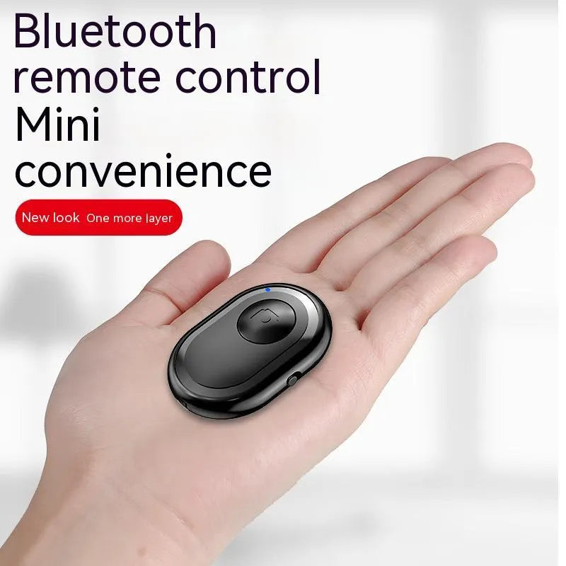 Small black wireless Bluetooth remote control for smartphone camera with self-timer function.