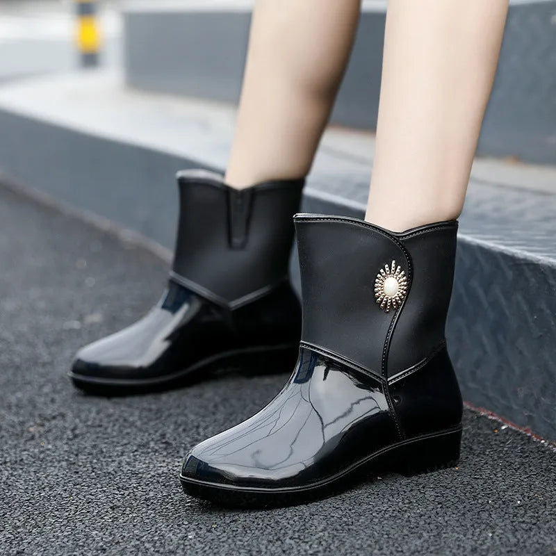 Women's purple PVC rain boot with non-slip sole on a wet surface.