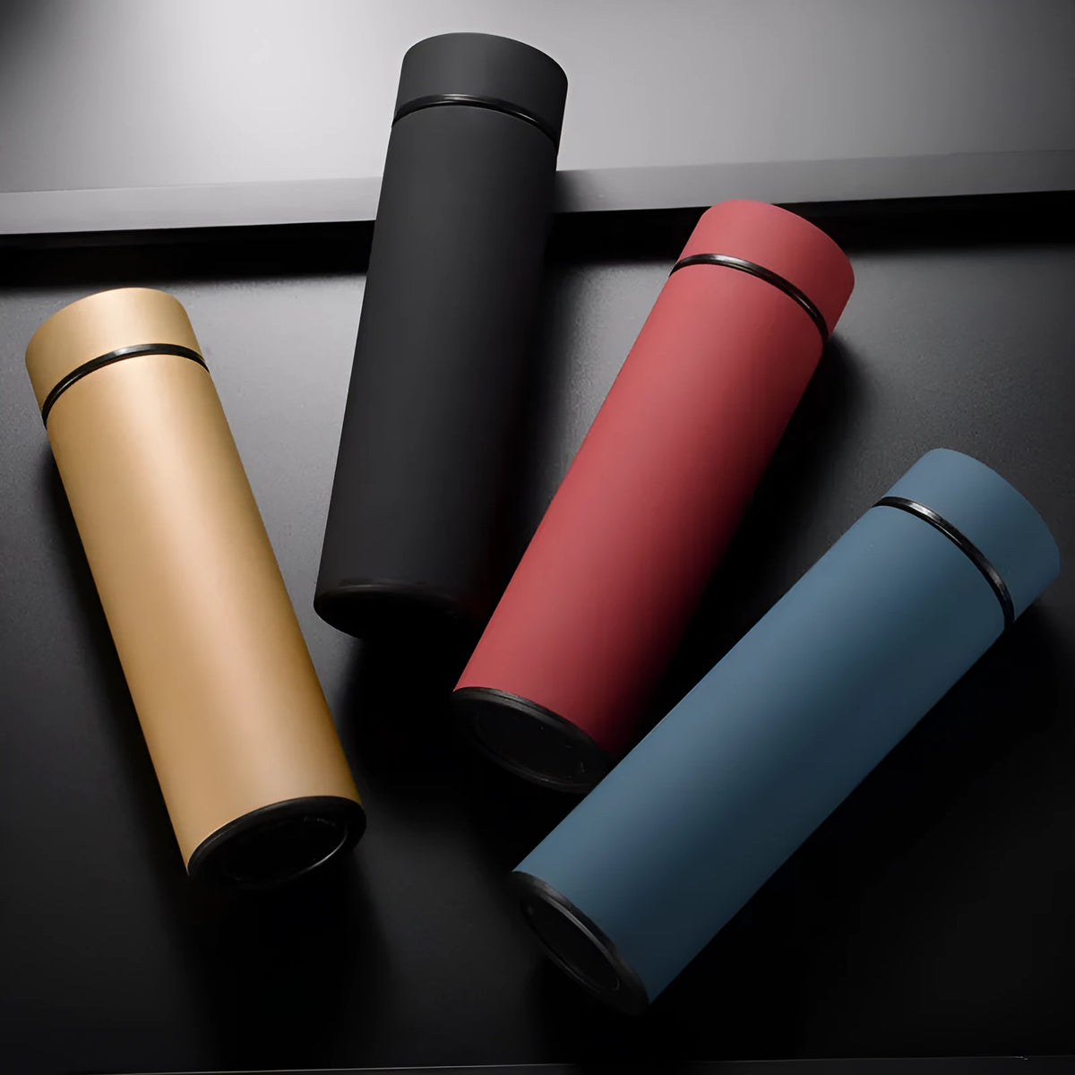 Stainless steel water bottle with double-wall vacuum insulation, shown in black, red, gold, and blue colour options.