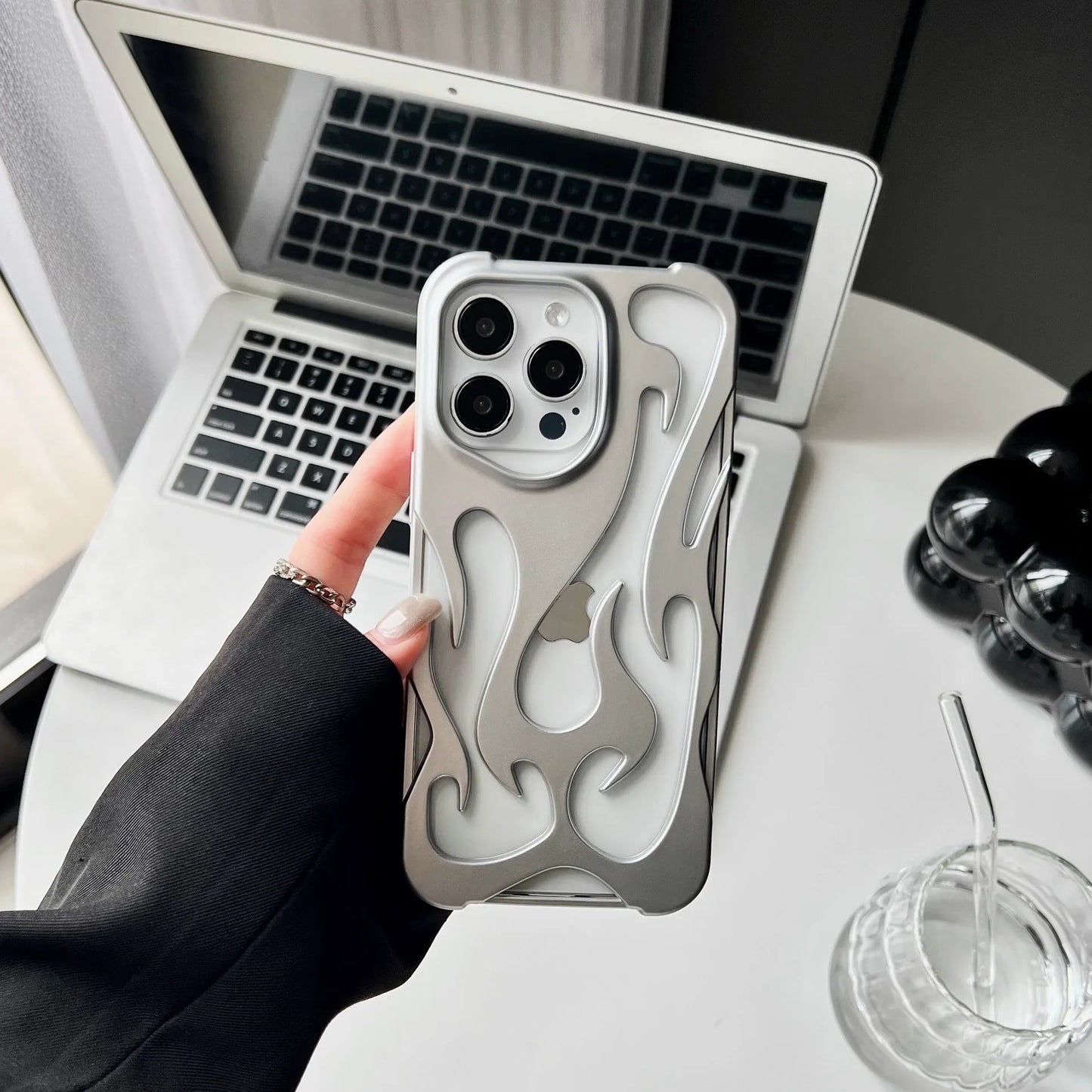 Electroplated hollow flame pattern phone case in silver plated finish on Apple iPhone, showing heat dissipation design and TPU soft shell