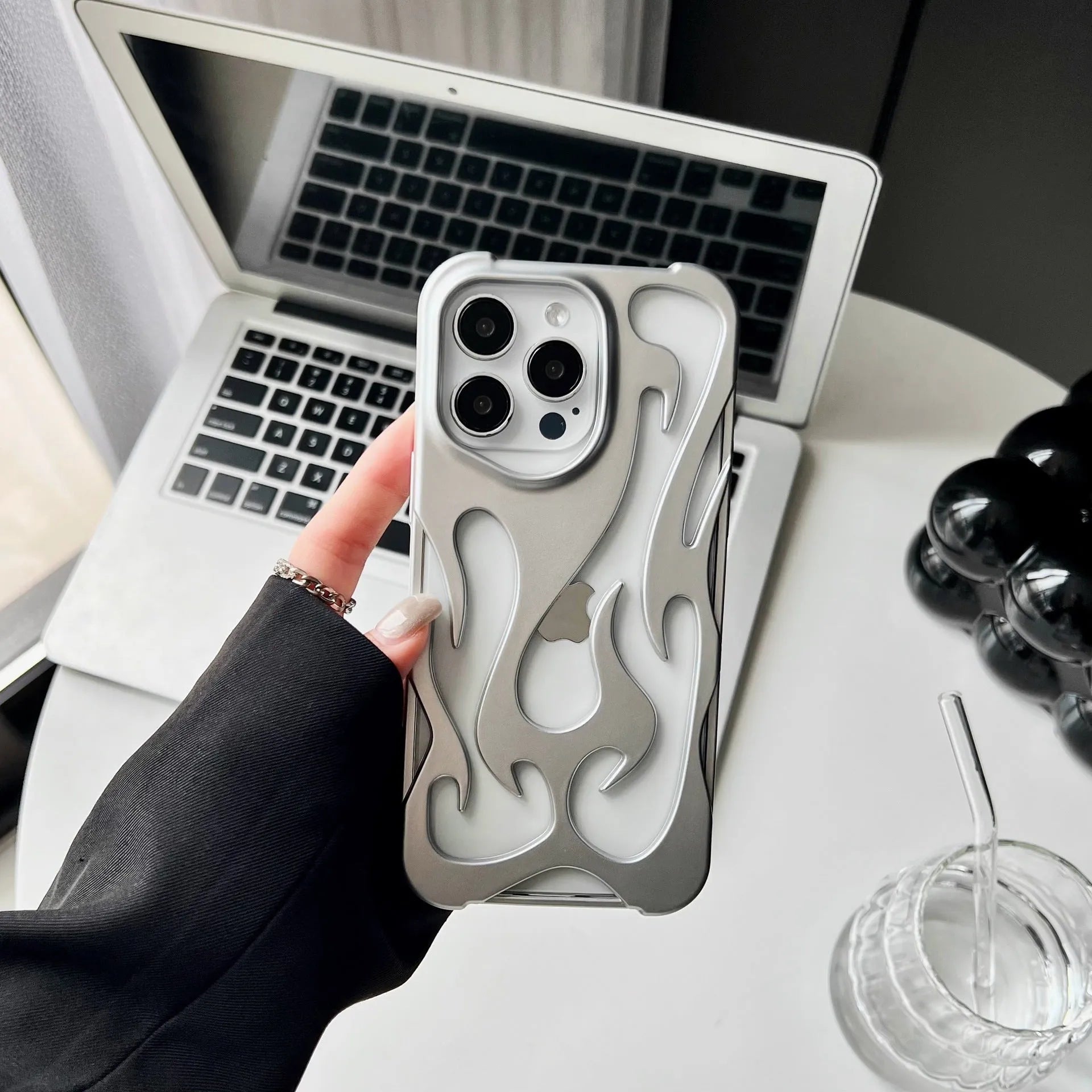 Electroplated hollow flame pattern phone case in silver plated finish on Apple iPhone, showing heat dissipation design and TPU soft shell