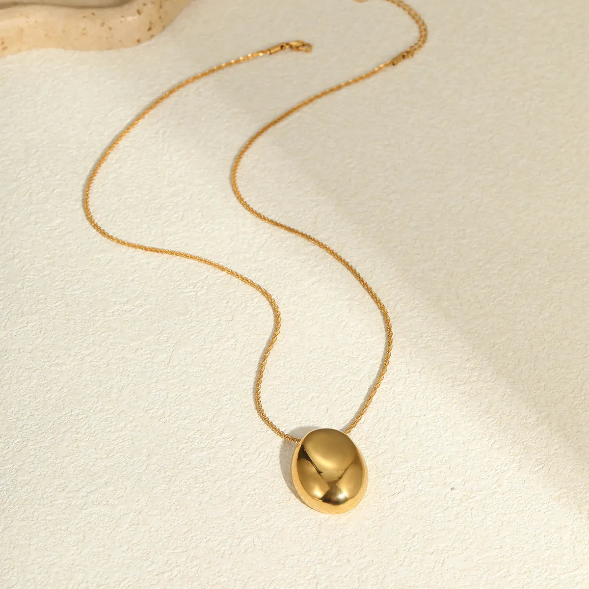 Gold-toned geometric pendant necklace on a chain, showing adjustable length between 41 cm and 50 cm.