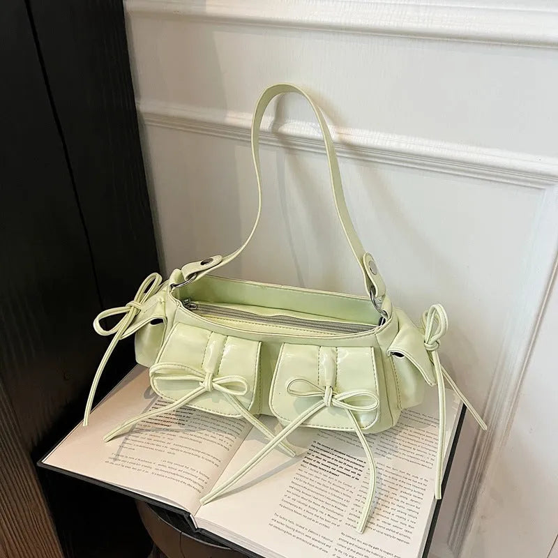 Women's tassel bow shoulder bag in pleated design with multiple pockets, shown in a selected colour.