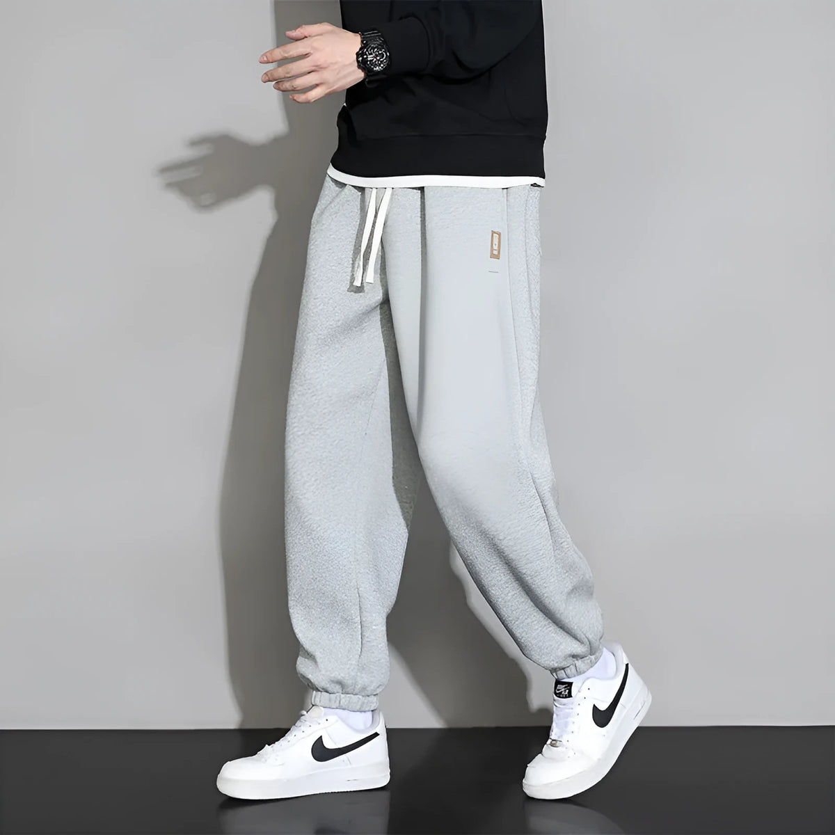 Men's loose gray casual sports trousers with drawstring waist on a hanger