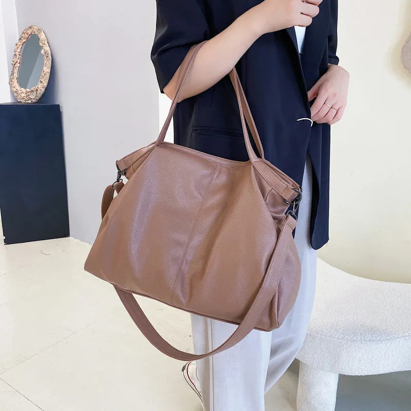 Large soft black PU messenger bag with long shoulder strap and front car suture detailing
