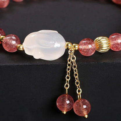 Women's strawberry quartz agate bracelet with 6mm round beads and white rabbit charm.
