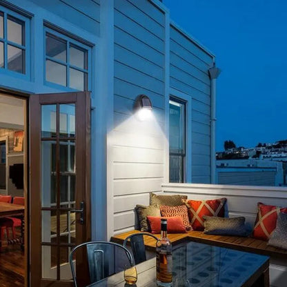 Black rectangular LED solar wall light mounted on an outdoor wall with a visible solar panel.