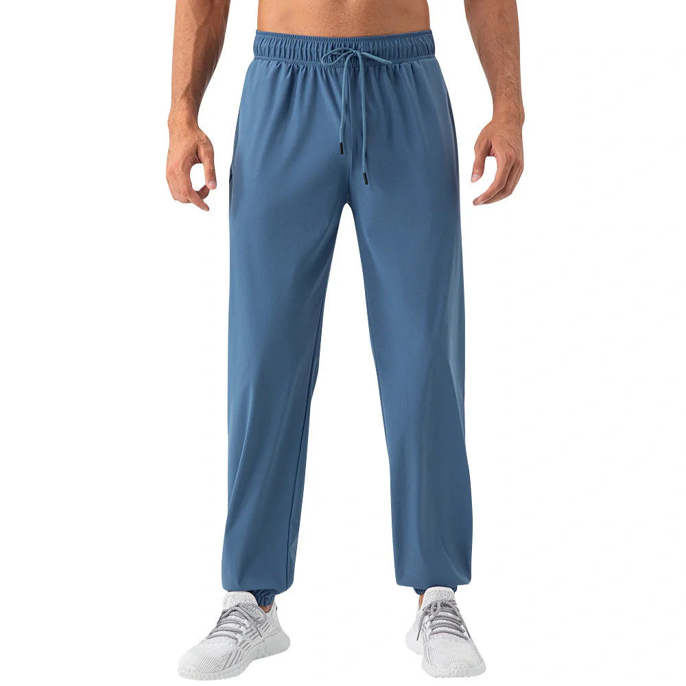 Men's lightweight nylon track pants in various colors, featuring a relaxed, flexible fit for active lifestyles