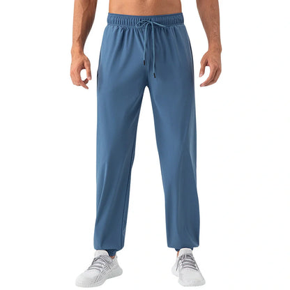 Men's lightweight nylon track pants in various colors, featuring a relaxed, flexible fit for active lifestyles