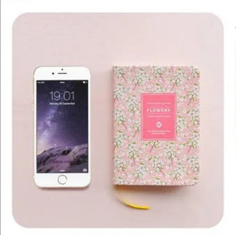 Bo Shide floral notepad with fabric-imitation leather cover in green, shown open on a desk.