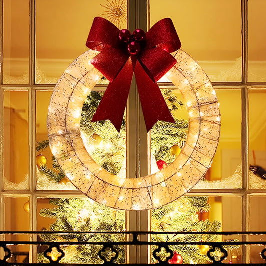 Gold and green LED luminous Christmas wreath with large bow, 50cm diameter, hanging on a door