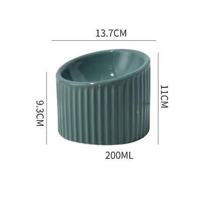 Ceramic raised cat bowl in light green, showing elevated tilted design for pet feeding.