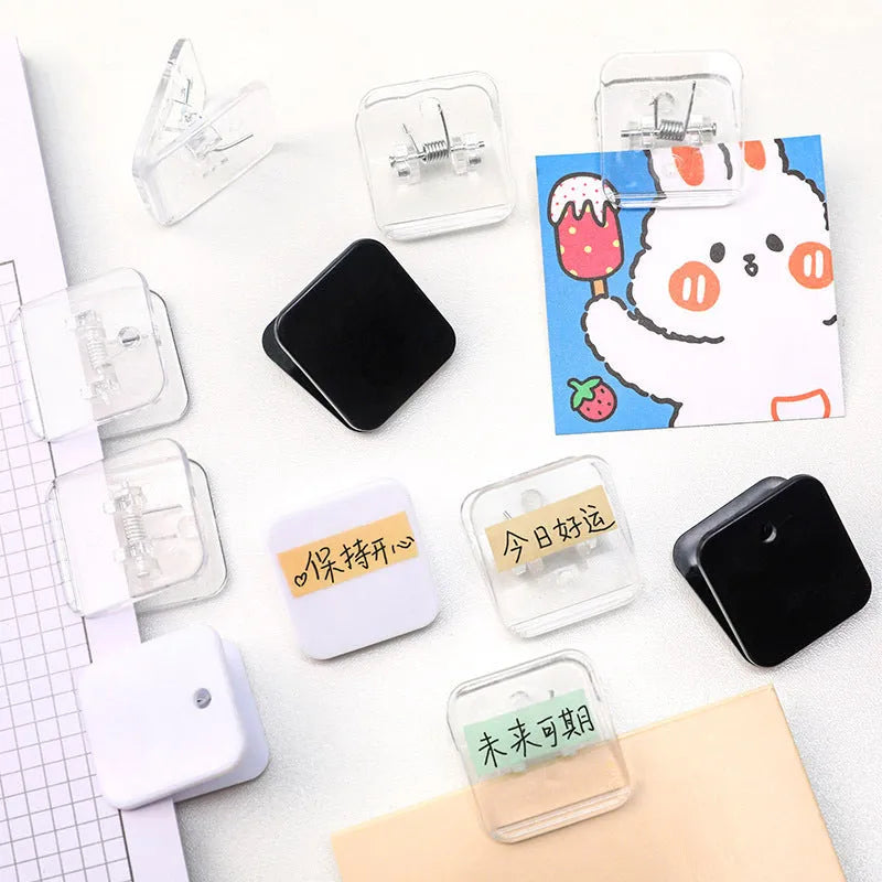 Square plastic photo holder in black, white, and transparent colour options on desk