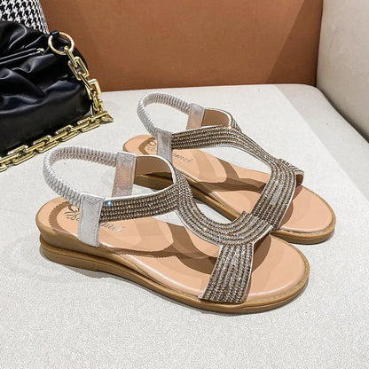 Gold patent leather women's sandals with rhinestone decoration on the strap.