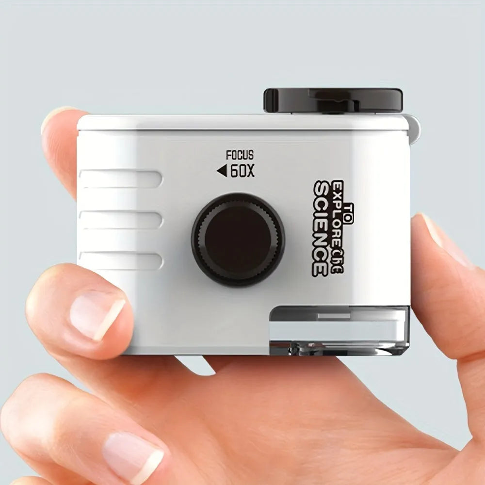White mini mobile phone microscope with LED light and detachable clip-on adapter next to a smartphone.