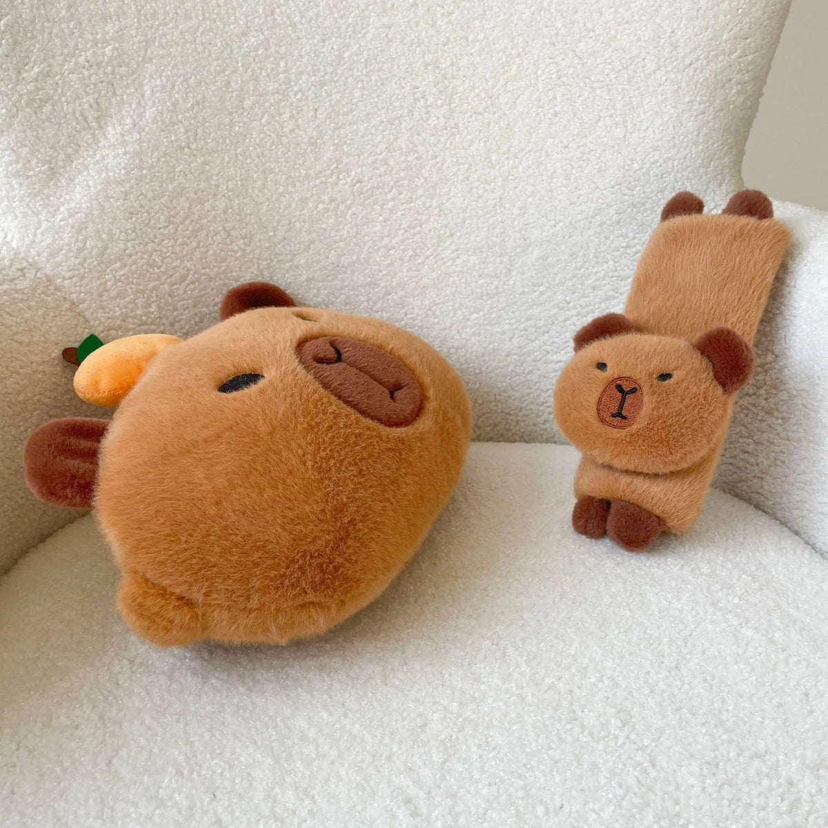 Khaki capybara car pillow in artificial plush with synthetic fibre filling, shown as a car neck pillow or shoulder cover.