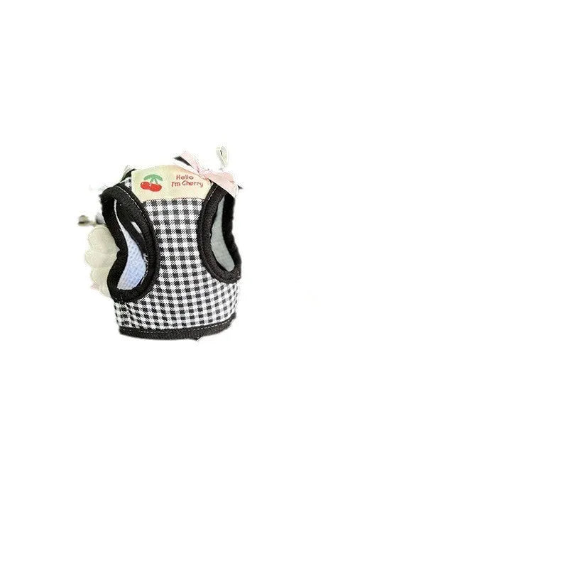 Small dog wearing adjustable cotton harness in pink with chest-back design and hand holding rope attachment